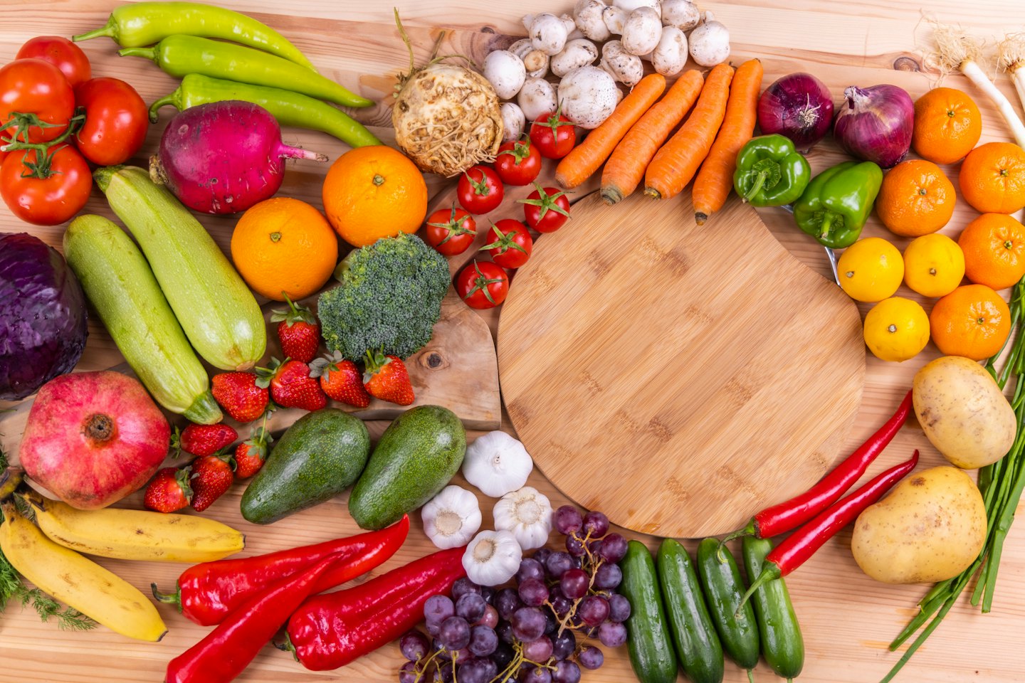 Auswahl an frischem Obst und Gemüse auf einer Holzoberfläche.